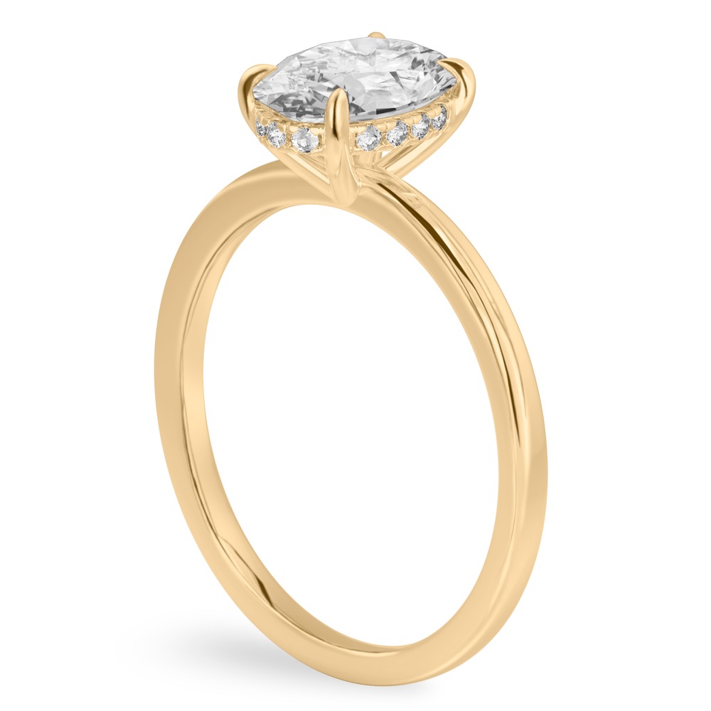 Angle view of oval shape diamond ultra low hidden halo engagement ring in yellow gold